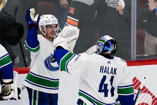 Vancouver Canucks center Bo Horvat (53) celebrates with Canucks goaltender Jaroslav Halak (41) after the tema's NHL hockey game against the Arizona Coyotes on Thursday, April 7, 2022, in Glendale, Ariz. The Canucks won 5-1. (AP Photo/Ross D. Franklin)