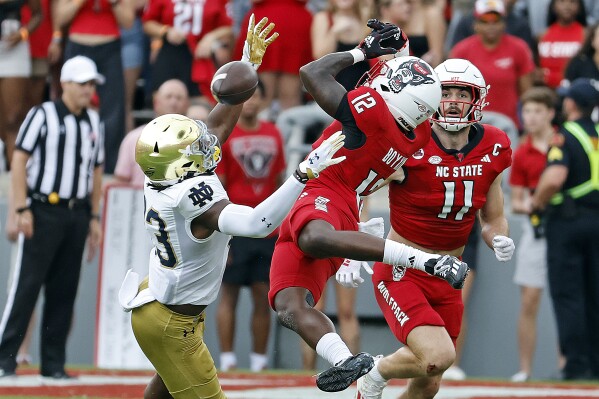 North Carolina State's Devan Boykin (12) breaks up a pass intended for Notre Dame's Jayden Thomas (83) with State's Payton Wilson (11) looking on during the first half of an NCAA college football game in Raleigh, N.C., Saturday, Sept. 9, 2023. (AP Photo/Karl B DeBlaker)