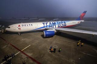 In this photo provided by Delta Air Lines, Delta Air Lines unveils its custom Team USA aircraft livery Friday, Dec. 17, 2021, at Delta TechOps facilities in Atlanta. This year, Delta began its sponsorship of the U.S. team that will make it the team's official airline through the LA Olympics in 2028. (Chris Rank/Delta Air Lines via AP)
