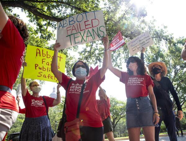 Susan Pintchovski, center, Nicole Golden, right, Dottie Wood and other members of Moms Demand Action protest in front of the Texas Governor's Mansion, Thursday, June 17, 2021, in Austin, Texas, after Gov. Greg Abbott signed a bill Wednesday that would allow Texans who are 21 years old or older to carry handguns without a permit. The permit-less carry measure will go into effect Sept. 1. (Ana Ramirez/Austin American-Statesman via AP)
