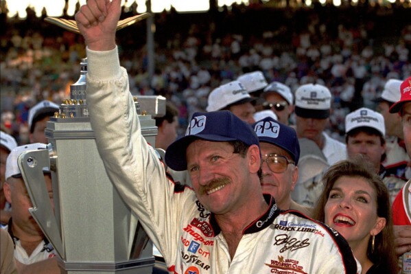 FILE - NASCAR driver Dale Earnhardt of Mooresville, N.C., gestures to the crowd from after winning the Brickyard 500 auto race at Indianapolis Motor Speedway, Saturday, Aug. 5, 1995. To mark NASCAR’s 75th season, The Associated Press interviewed 12 key contributors to the industry on multiple topics. According to the survey, Dale Earnhardt's death in the 2001 Daytona 500 was picked as NASCAR's most pivotal moment. (AP Photo/Tom Strattman, File)
