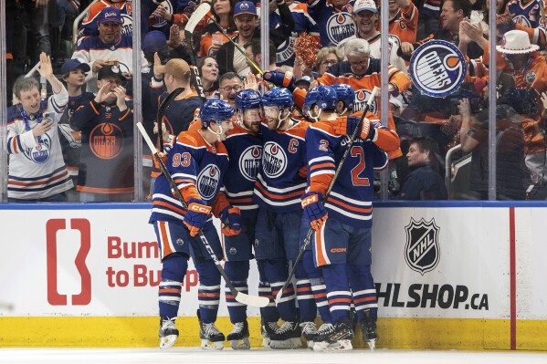 Edmonton Oilers' Ryan Nugent-Hopkins (93), Zach Hyman (18), Connor McDavid (97) and Evan Bouchard (2) celebrate after a goal against the Dallas Stars during first-period action in Game 6 of the Western Conference finals of the NHL Stanley Cup playoffs in Edmonton, Alberta, Sunday June 2, 2024. (Jason Franson/The Canadian Press via AP)