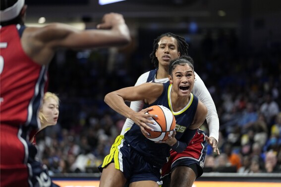 Dallas Wings forward Satou Sabally, front right, works to the basket against Washington Mystics' Cyesha Goree, back right, in the first half of a WNBA basketball game, Friday, July 28, 2023, in Arlington, Texas. (AP Photo/Tony Gutierrez)