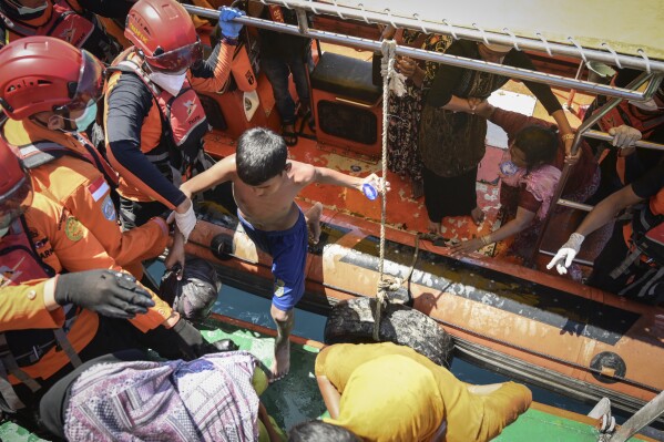 Ethnic Rohingya refugees board a National Search and Rescue Agency ship after being rescued from their capsized boat in the waters off West Aceh, Indonesia, on Thursday, March 21, 2024. The wooden fishing boat carried about 140 Rohingya refugees, but only 75 people were rescued. In interviews with The Associated Press, eight of the survivors described abuses on board the fishing boat. (AP Photo/Reza Saifullah)