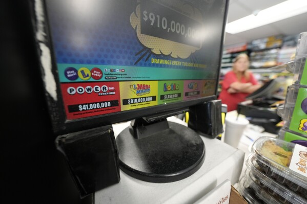 A display for the Mega Millions lottery is seen at the Save 'N Time convenience store in Harahan, La., Wednesday, July 26, 2023. The Mega Millions lottery jackpot is approaching $1 billion ahead of Friday’s drawing. (AP Photo/Gerald Herbert)