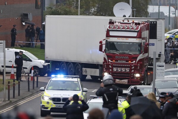 FILE - Police escort the truck, that was found to contain a large number of dead bodies, as they move it from an industrial estate in Thurrock, south England, Oct. 23, 2019. The final member convicted in a London court for a migrant smuggling ring that was responsible for the deaths of 39 Vietnamese immigrants who suffocated in a shipping container was sentenced Thursday Nov. 30, 2023. (AP Photo/Alastair Grant, File)