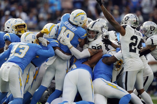 Los Angeles Chargers quarterback Justin Herbert (10) is stopped on fourth and one by Las Vegas Raiders defensive end Maxx Crosby (98) during the second half of an NFL football game Sunday, Oct. 1, 2023, in Inglewood, Calif. (AP Photo/Ryan Sun)