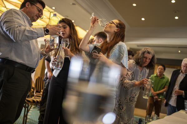 People sample glasses of fine water during an international water tasting competition held in Athens, Greece, on Wednesday, April 26, 2023. This year’s champions in each category, from still water to sparkling and super-low minerality to high, came from Austria, New Zealand, Panama, Scandinavia and other parts of the world. (AP Photo/Petros Giannakouris)