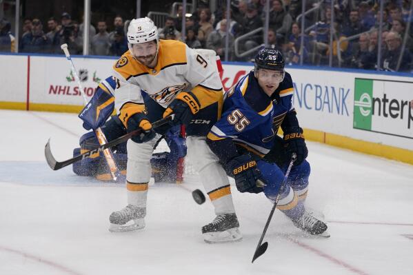 Nashville Predators' Filip Forsberg (9) and St. Louis Blues' Colton Parayko chase after a loose puck during the third period of an NHL hockey game Monday, Dec. 12, 2022, in St. Louis. (AP Photo/Jeff Roberson)