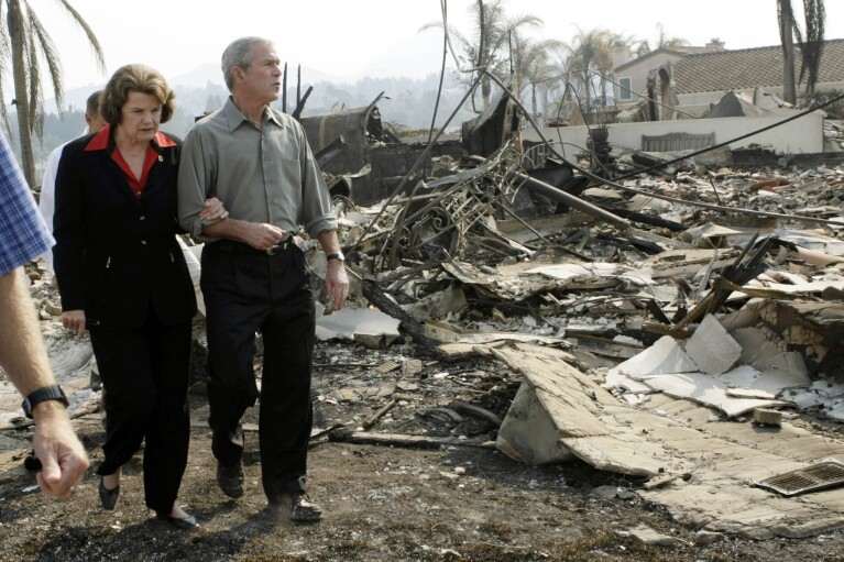 FILE - President George W. Bush, right, escorts U.S. Sen. Dianne Feinstein, D-Calif., as they walk through the remains of a home that was damaged by the California wildfires, Thursday, Oct. 25, 2007, in San Diego. (AP Photo/Pablo Martinez Monsivais, File)