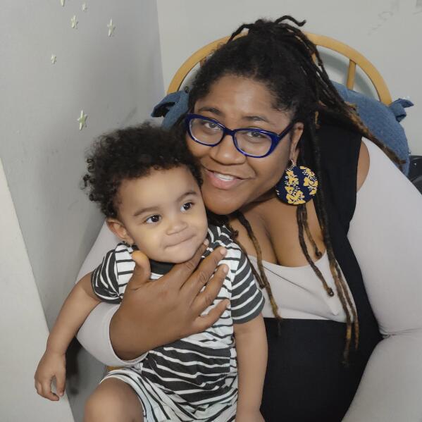 This May 2022 photo provided by Ana Rodney shows her with her son, Asher, at home in Baltimore. Rodney, who runs MOMCares, a Baltimore organization that provides baby supplies and support to new mothers in the city's Black community, said the baby formula shortage has hit many families there hard. Formula feeding is typically more common among Black women _ often because they don't get breastfeeding encouragement or support from the white medical community, Rodney said. (Courtesy Ana Rodney via AP)
