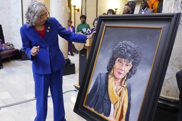 Former State Rep. Alyce Clarke, D-Jackson, inspects her official portrait in the Mississippi State Capitol in Jackson, Miss., Tuesday, Feb. 13, 2024. Clarke is the first woman and the first African American to have a portrait displayed in the state Capitol. (AP Photo/Rogelio V. Solis)