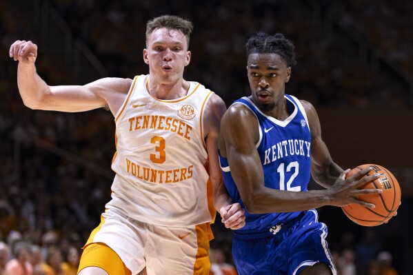Kentucky guard Antonio Reeves (12) drives as he is defended by Tennessee guard Dalton Knecht (3) during the second half of an NCAA college basketball game Saturday, March 9, 2024, in Knoxville, Tenn. (AP Photo/Wade Payne)