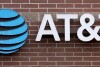 FILE - The company logo hangs over the door to an AT&T store Thursday, Feb. 22, 2024, in Denver. AT&T says it will give affected customers $5 each to compensate for last week's cellphone network outage that left many without service for hours.(AP Photo/David Zalubowski, File)
