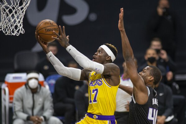 Los Angeles Lakers guard Dennis Schroder (17) scores a basket as he is defended by Sacramento Kings forward Harrison Barnes (40) during the first quarter of an NBA basketball game in Sacramento, Calif., Friday, April 2, 2021. (AP Photo/Hector Amezcua)