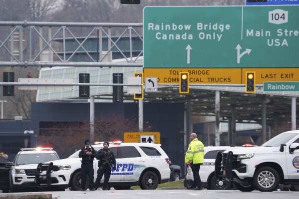 FILE - Law enforcement personnel block off the entrance to the Rainbow Bridge, Wednesday, Nov. 22, 2023, in Niagara Falls, N.Y. The two people killed when their car crashed into a border checkpoint in Niagara Falls have been identified as a western New York couple. The Niagara Falls Police Department on Friday, Nov. 24, named the victims as Kurt P. Villani and Monica Villani of Grand Island, New York, a leafy Buffalo suburb close to the falls. (Derek Gee/The Buffalo News via AP, file)