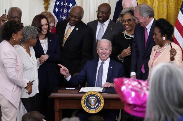 President Joe Biden points to Opal Lee after signing the Juneteenth National Independence Day Act, in the East Room of the White House, Thursday, June 17, 2021, in Washington. From left, Rep. Barbara Lee, D-Calif, Rep. Danny Davis, D-Ill., Opal Lee, Sen. Tina Smith, D-Minn., Vice President Kamala Harris, House Majority Whip James Clyburn of S.C., Sen. Raphael Warnock, D-Ga., Sen. John Cornyn, R-Texas, obscured, Rep. Joyce Beatty, D-Ohio, Sen. Ed Markey, D-Mass., and Rep. Sheila Jackson Lee, D-Texas. (AP Photo/Evan Vucci)