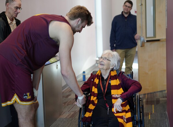 Loyola University basketball player, Tom Welch, shakes hands with Sister Jean Dolores Schmidt, the team's official chaplain, before attending practice on Monday, Jan. 23, 2023, in Chicago. The beloved Catholic nun captured the world's imagination and became something of a folk hero while supporting the Ramblers at the NCAA Final Four in 2018. At the age of 103, Sister Jean is using her platform to publish her first book, "Wake Up with Purpose: What I've Learned in My First Hundred Years." In the memoir she tells her story and offers life lessons and spiritual guidance. (AP Photo/Jessie Wardarski)