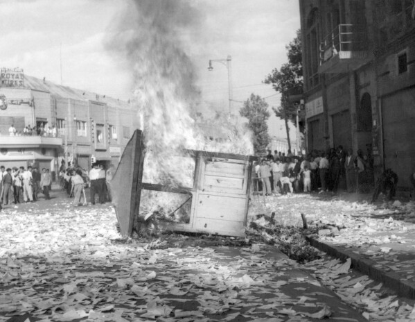 FILE - A Communist newspaper kiosk burned by pro-shah demonstrators after the coup d'etat which ousted Prime Minister Mohammad Mossadegh, in Tehran, Iran on Aug. 19, 1953. While revealing new details about one of the most famed CIA operations of all times, the spiriting out of six American diplomats who escaped the 1979 U.S. Embassy seizure in Iran, the intelligence agency for the first time has acknowledged something else as well. The CIA now officially describes the 1953 coup it backed in Iran that overthrew its prime minister and cemented the rule of Shah Mohammad Reza Pahlavi as undemocratic. (AP Photo, File)