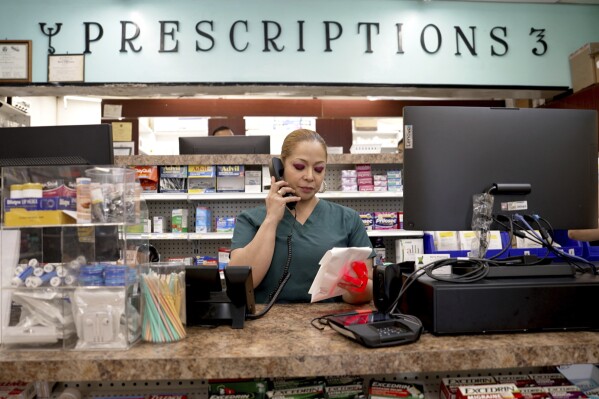 Carmen Lopez works at Bert's Pharmacy in Elizabeth, N.J., on May 21, 2024. The business is located in an ZIP code where nearly 70% of the residents are Hispanic. (AP Photo/Shelby Lum)