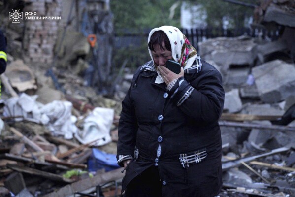 In this photo provided by the Ukrainian Emergency Service, a local resident cries standing amid the rubble of her house ruined after Russia's air attack in Khmelnytskyi region, Ukraine, Sunday, May 25, 2025. (Ukrainian Emergency Service via AP)