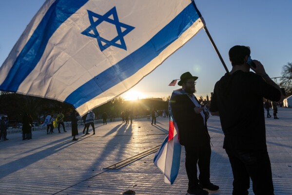 FILE - Menachem Roetter of Detroit, left, walks behind an Israeli flag at the end of the March for Israel rally on Nov. 14, 2023, on the National Mall in Washington. (AP Photo/Jacquelyn Martin, File)