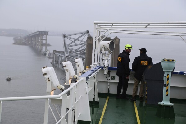 In this image released by the National Transportation and Safety Board, NTSB investigators on the cargo vessel Dali, which struck and collapsed the Francis Scott Key Bridge, Wednesday, March 27, 2024 in Baltimore. (Peter Knudson/NTSB via AP)