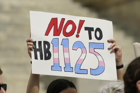 A protester holds a poster calling for lawmakers to vote against House Bill 1125, which would ban gender-affirming care for trans children at the Mississippi Capitol in Jackson, Wednesday, Feb. 15, 2023. (AP Photo/Rogelio V. Solis)