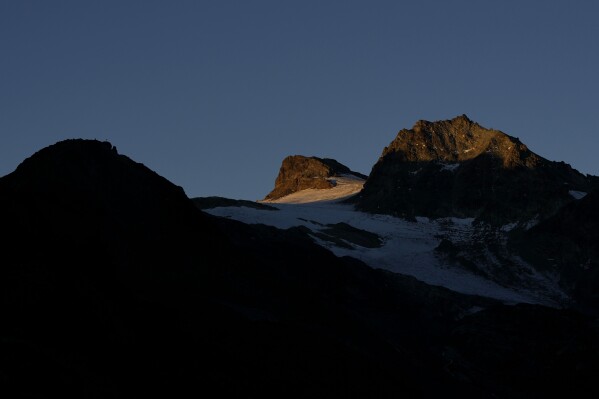 The sun rises at the Jamtalferner Glacier near Galtuer, Austria, Wednesday, Sept. 6, 2023. (AP Photo/Matthias Schrader)