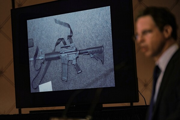 FILE - An image of the weapon used during the Newtown school shooting is displayed while attorney Josh Koskoff speaks during a news conference in Trumbull, Conn., Feb. 15, 2022. A federal judge on Thursday, Aug. 3, 2023, rejected a request to temporarily block Connecticut's landmark 2013 gun control law, passed after the Sandy Hook Elementary School shooting, until a gun rights group's lawsuit against the statute has concluded. (AP Photo/Seth Wenig, File)
