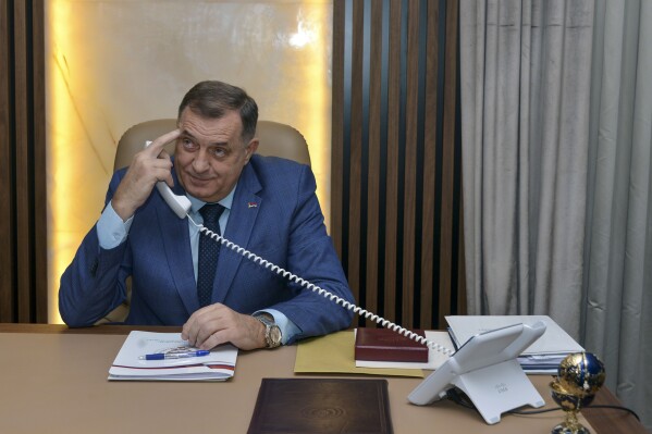 Bosnian Serb leader Milorad Dodik uses his phone prior to the start an interview with the Associated Press, in the Bosnian town of Banja Luka, 240 kms northwest of Sarajevo, Friday, Dec. 29, 2023. Bosnian Serb separatist leader wowed to carry on weakening his multiethnic, war-scarred country to the point where it will tear apart, despite the pledge by the United States to prevent such an outcome. 