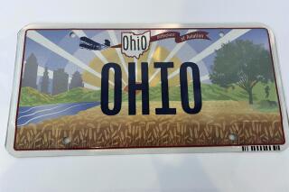 Ohio Gov. Mike DeWine on Thursday, Oct. 21, 2021, unveiled the new "Sunrise in Ohio" license plate in Columbus, Ohio. Ohio's new license plate failed to take off after the illustration of a banner in flight was attached to the wrong end of the Wright Brothers’ first plane. The new plate’s banner reads “Birthplace of Aviation.” The banner should have been trailing behind the plane but was attached to the front. (Jessie Balmert/The Cincinnati Enquirer via AP)