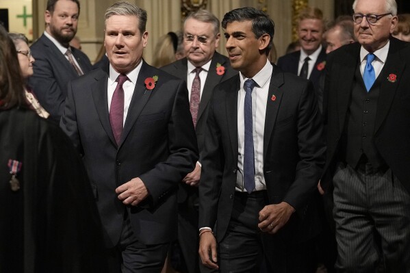 FILE - Britain's Prime Minister Rishi Sunak, right, and Labour Party leader Keir Starmer pass through the Peer's Lobby to attend the State Opening of Parliament at the Palace of Westminster in London, Tuesday, Nov. 7, 2023. (AP Photo/Alastair Grant, Pool, File)