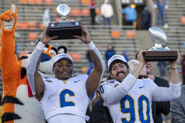 Pittsburgh running back Rodney Hammond Jr., left, and placekicker Ben Sauls lift their MVP trophies after their team won the Sun Bowl NCAA college football game against UCLA, Friday, Dec. 30, 2022, in El Paso, Texas. (AP Photo/Andres Leighton)