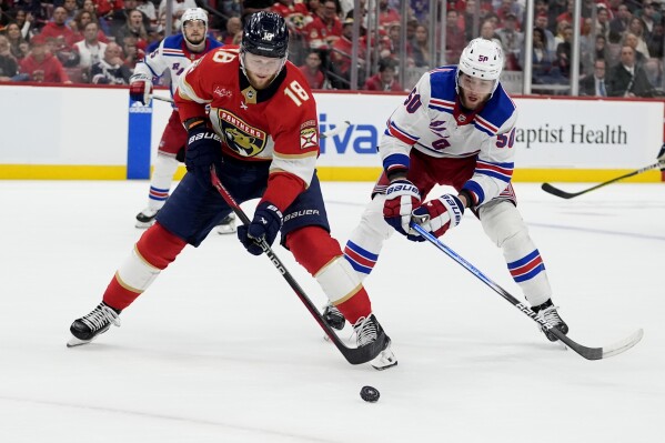 Florida Panthers center Steven Lorentz (18) skates with the puck as New York Rangers left wing Will Cuylle (50) defends during the second period of Game 6 in the Eastern Conference finals of the NHL hockey Stanley Cup playoffs Saturday, June 1, 2024, in Sunrise, Fla. (AP Photo/Lynne Sladky)