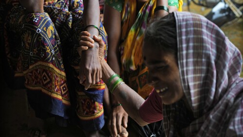 A woman holds the hand of her relative as family members of people trapped under rubble wail after a landslide washed away houses in Raigad district, western Maharashtra state, India, Thursday, July 20, 2023. While some people are reported dead many others feared trapped under piles of debris. (AP Photo/Rafiq Maqbool)