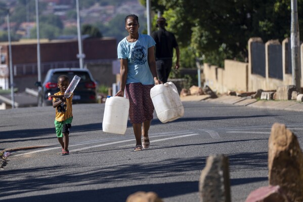 Residentes del municipio de Soweto, Sudáfrica, hacen cola para pedir agua el sábado 16 de marzo de 2024. Miles de sudafricanos hacen cola para pedir agua mientras la ciudad más grande del país, Johannesburgo, se enfrenta a un colapso sin precedentes de su sistema de agua, que afecta a millones de personas.  Los residentes ricos y pobres nunca han experimentado una escasez de esta gravedad.  (Foto AP/Jérôme Delay)