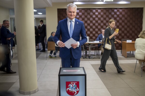 Lithuania's President Gitanas Nauseda, a presidential candidate, prepares to cast his ballot at a polling station during the advance presidential elections in the small town of Svencionys, some 85km (52,8 miles) north of the capital Vilnius, Lithuania, Thursday, May 23, 2024. The second round of presidential vote in Lithuania will take place on May 26. Lithuania's incumbent president won the most votes in the first round with 44% of the votes but he still faces a runoff against the country's prime minister. (AP Photo/Mindaugas Kulbis)