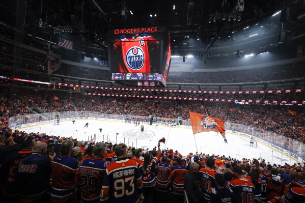 Edmonton Oilers fans cheers their team before the start of the first period of Game 6 of the Western Conference finals of the NHL Stanley Cup playoffs in Edmonton, Alberta, Sunday June 2, 2024. (Jeff McIntosh/The Canadian Press via AP)