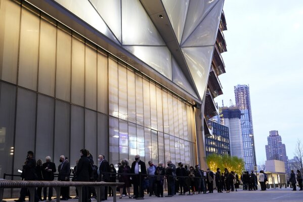 People line up outside The Shed before a live performance by the New York Philharmonic, whose members performed together for the first time since March 2020, on Wednesday, April 14, 2021, at Hudson Yards in New York. Normal subscription performances are to resume in September. (AP Photo/Kathy Willens)
