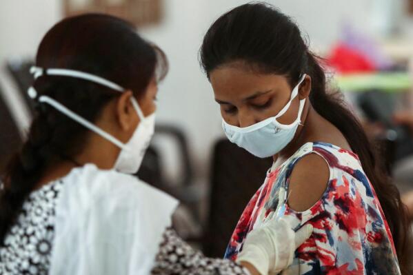 A girl receives a dose of coronavirus vaccine at a vaccination center in Jammu, India, Monday, June 5, 2021. (AP Photo/Channi Anand)