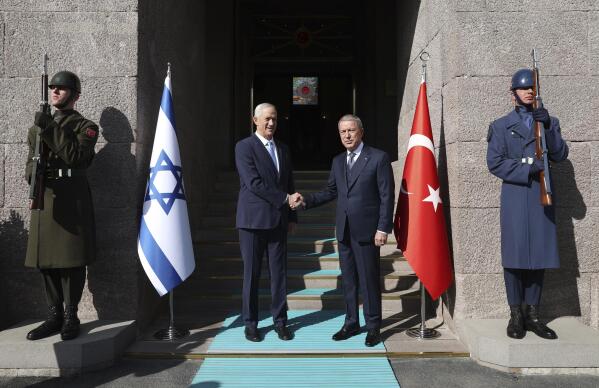 In this handout photo provided by the Turkish Defense Ministry, Turkish Defense Minister Hulusi Akar, right, and Israel's Defense Minister Benny Gantz shake hands during a welcome ceremony in Ankara, Turkey, Thursday, Oct. 27, 2022. Gantz met with his Turkish counterpart on Thursday, making the first visit by a top Israeli defense official to Turkey in more than a decade, as the two countries take steps to normalize their strained ties.( Turkish Defense Ministry via AP)