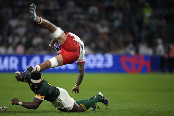 South Africa's captain Siya Kolisi, bottom, tackles Tonga's captain Halaleva Fifita during the Rugby World Cup Pool B match between South Africa and Tonga at the Marseille's Stade Velodrome, in Marseille, France Sunday, Oct. 1, 2023. (AP Photo/Daniel Cole)