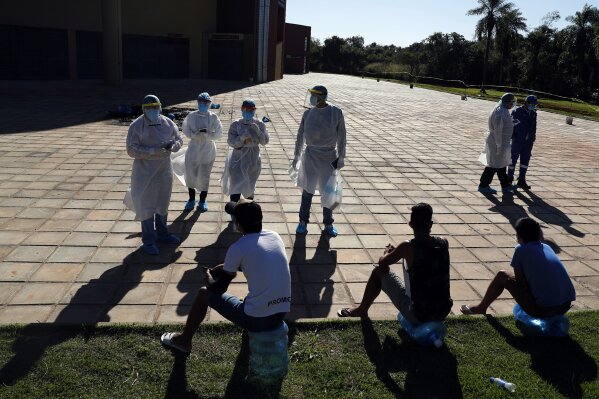 Members of the National Mechanism to Prevent Torture (MNPT) interview youths at a sports facility that was turned into a government-run shelter where citizens returning home are required by law to quarantine for two weeks and pass two consecutive COVID-19 tests, as a preventive measure amid the COVID-19 pandemic in Hermandarias, Paraguay, near the border with Brazil, Thursday, June 24, 2020. With only 7 million people, a stagnant economy, high poverty, and a weak public health system, Paraguay moved to slow coronavirus in March by closing borders and imposing the quarantine restrictions, along with closing schools and public events and declaring a nighttime curfew.  (AP Photo/Jorge Saenz)