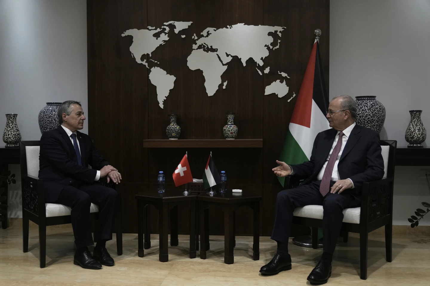Swiss Federal Councillor Ignazio Cassis, left, shakes hands with Palestinian Prime Minister Mohammad Mustafa, right, in the West Bank city of Ramallah