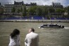FILE - People sit along the Seine River with stands installed on its banks, July 4, 2024, in Paris. (AP Photo/Thibault Camus, File)