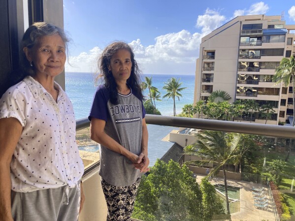Evangeline Balintona, left, and Elsie Rosales pose on the balcony of a hotel room in Lahaina, Hawaii, on Thursday, Aug. 31, 2023. They are among the many Filipinos who work as Maui hotel housekeepers living temporarily in hotel rooms after losing their homes to a deadly fire. (AP Photo/Jennifer Sinco Kelleher)