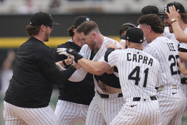Chicago White Sox's Tim Elko (30), center, is swarmed by his teammates after he hit a walk-off single to defeat the Detroit Tigers in a baseball game Thursday, June 5, 2025, in Chicago. (AP Photo/Erin Hooley)