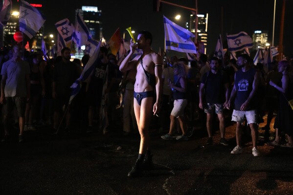 Demonstrators protest against plans by Prime Minister Benjamin Netanyahu's government to overhaul the judicial system, in Tel Aviv, Monday, July 24, 2023. Israeli lawmakers on Monday approved a key portion of Prime Minister Benjamin Netanyahu's divisive plan to reshape the country's justice system despite massive protests that have exposed unprecedented fissures in Israeli society. (AP Photo/Ariel Schalit)
