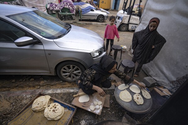 Palestinians displaced by the Israeli bombardment of the Gaza Strip prepare bread in a UNDP-provided tent camp in Khan Younis, Wednesday, Nov.15, 2023. (AP Photo/Fatima Shbair)
